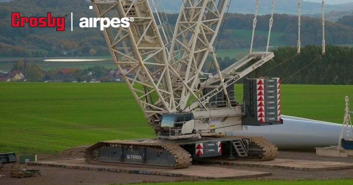 Grúa de alto rendimiento preparándose para construir la base de un aerogenerador