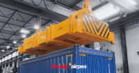 Hydraulic lifting spreader beam by Crosby Airpes lifting a 40-foot container with twist lock system and status lights in port environment.