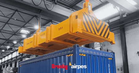 Hydraulic lifting spreader beam by Crosby Airpes lifting a 40-foot container with twist lock system and status lights in port environment.