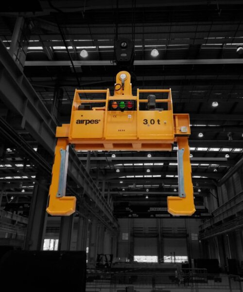 3 Close-up of a crane lifting a steel coil with heavy-duty coil tongs