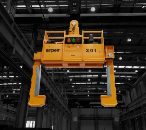 3 Close-up of a crane lifting a steel coil with heavy-duty coil tongs