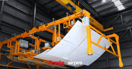 Sistema de elevación y manipulación industrial de Crosby Airpes con viga de izado para el manejo seguro de grandes paneles en planta de producción.