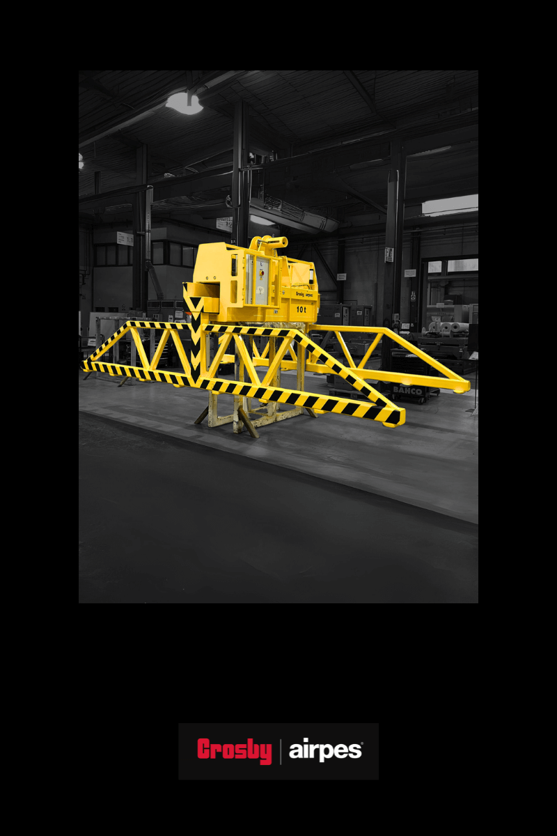 Crosby Airpes 10-ton motorized metal sheet clamp displayed inside an industrial workshop, featuring a robust yellow structure designed for safe and efficient heavy-duty lifting