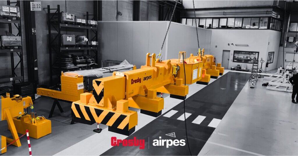 Overhead electromagnet lifting heavy steel components in an industrial workshop using a crane system by Crosby Airpes.