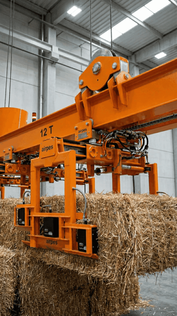 Lifting beam for straw bale handling as part of a biomass fuel handling system